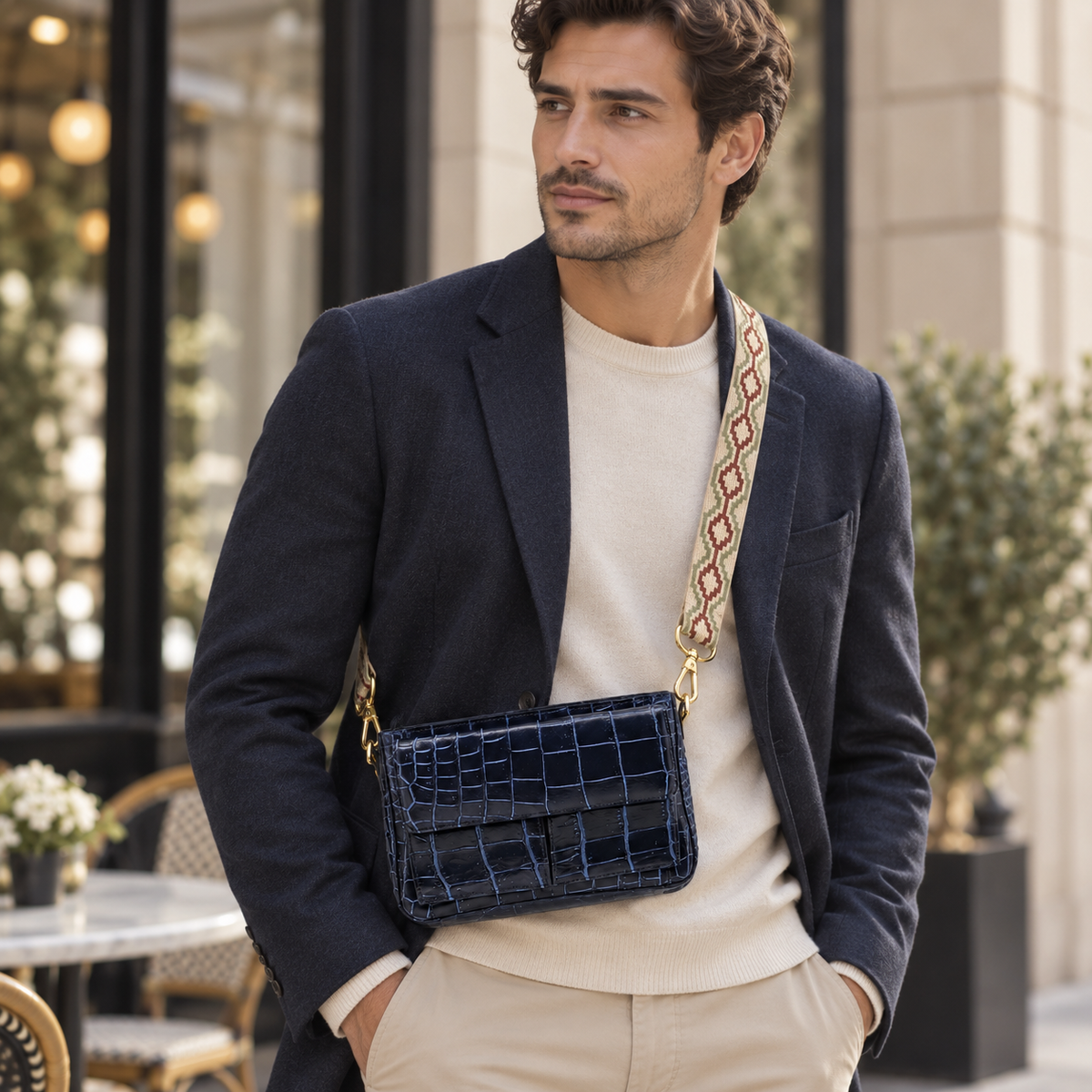 Man wearing The Alderley Crocodile Shoulder Bag crossbody with the adjustable woven strap in an elegant city setting