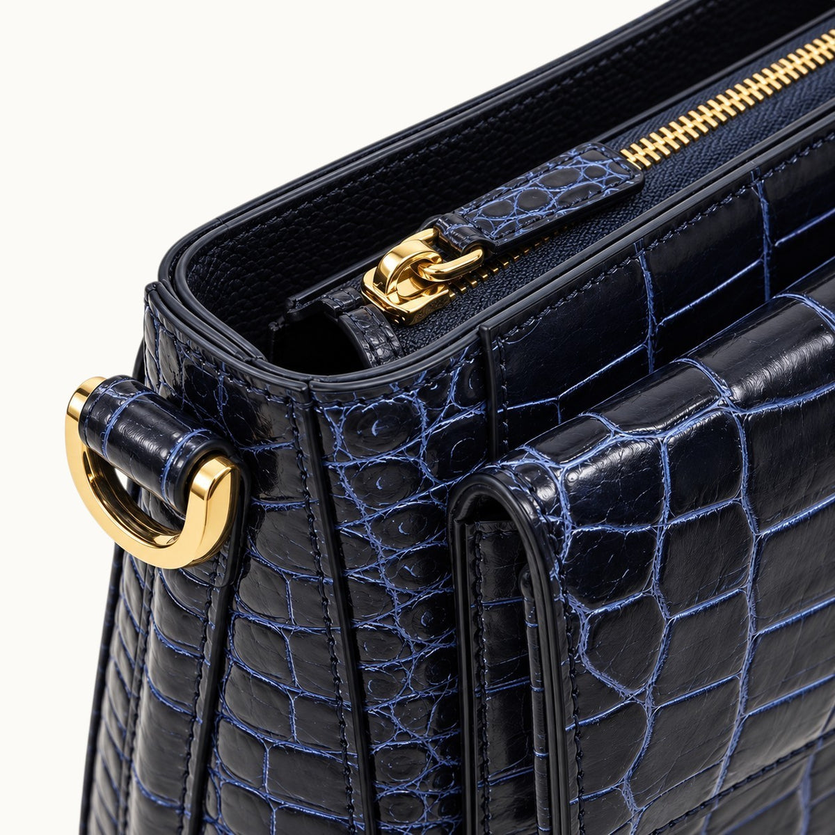 Close-up of The Alderley Crocodile Shoulder Bag showing gold-tone zipper, crocodile zipper pull, D-ring and edge finishing