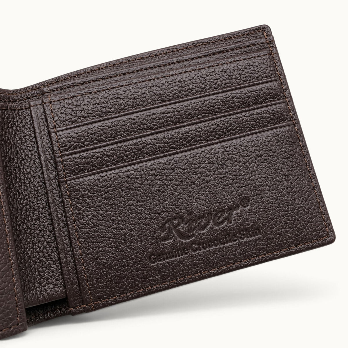 Close-up of The Ashford wallet interior featuring premium brown full-grain calf leather, card slots, fine stitching, and embossed RIVER Genuine Crocodile Skin logo.