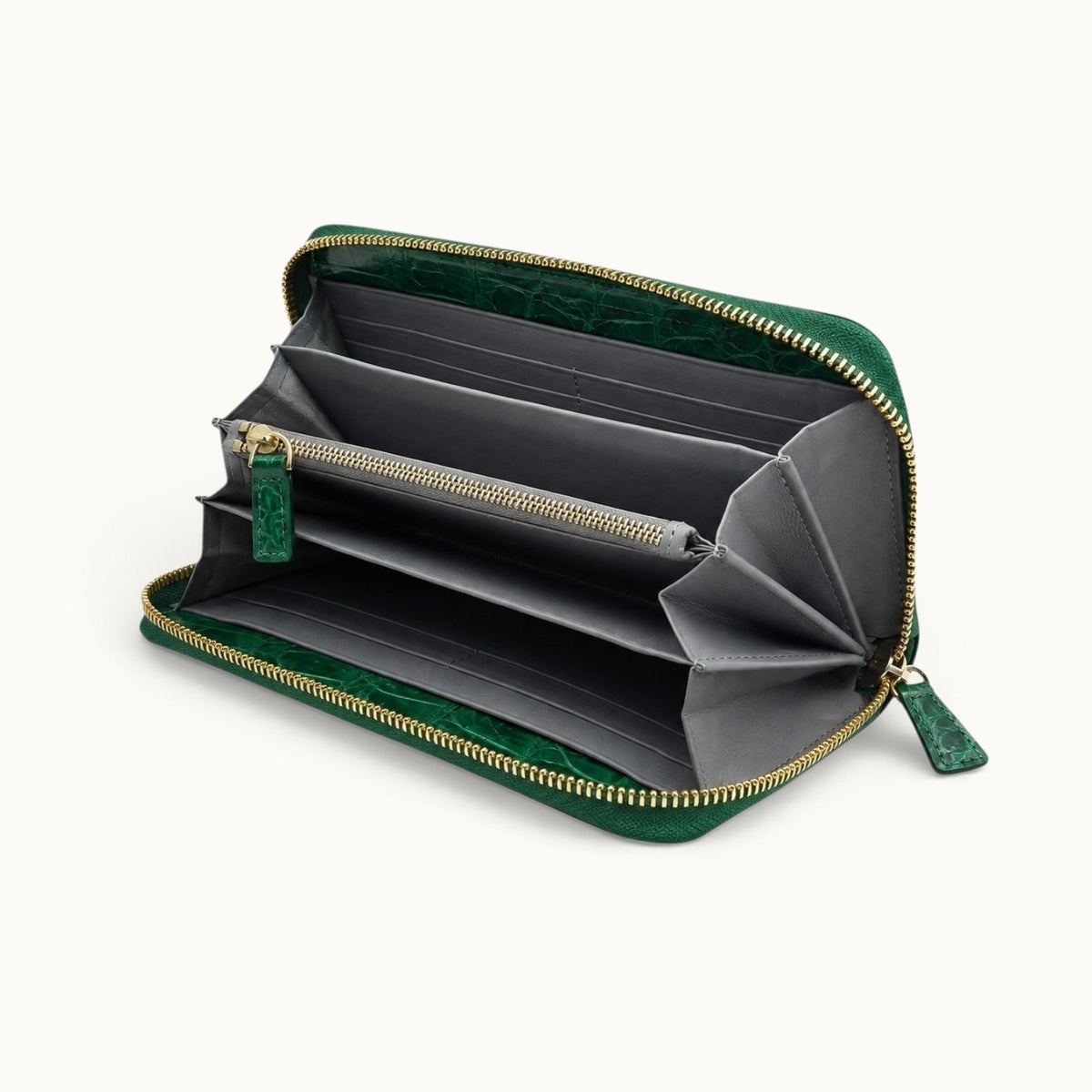 Angled interior view of the Belvedere Siamese crocodile zip-around wallet in Emerald Green with gray lambskin lining, divided compartments, card slots, and central zip pocket