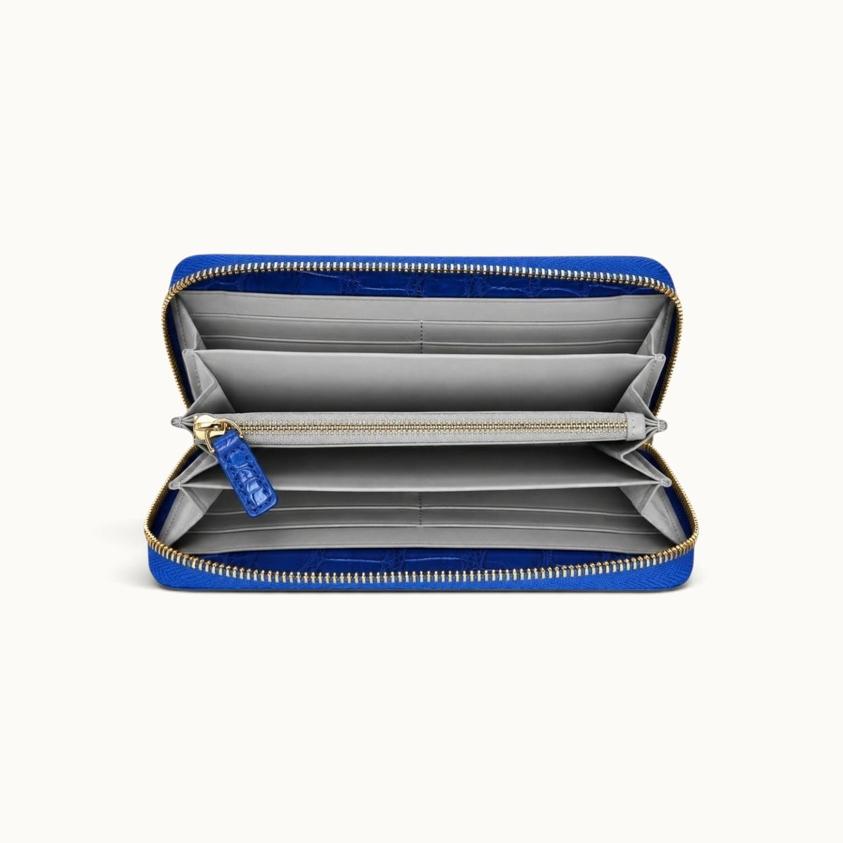Front interior view of the Belvedere Siamese crocodile zip-around wallet in Royal Blue with gray lambskin lining, card slots, divided compartments, and central zip pocket