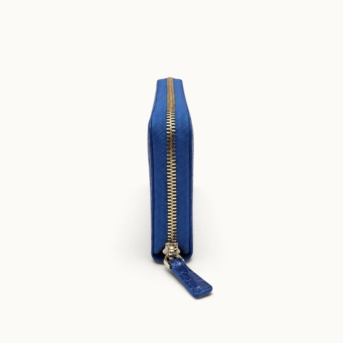 Side view of the Belvedere Siamese crocodile zip-around wallet in Royal Blue showing its slim profile and zip-around closure