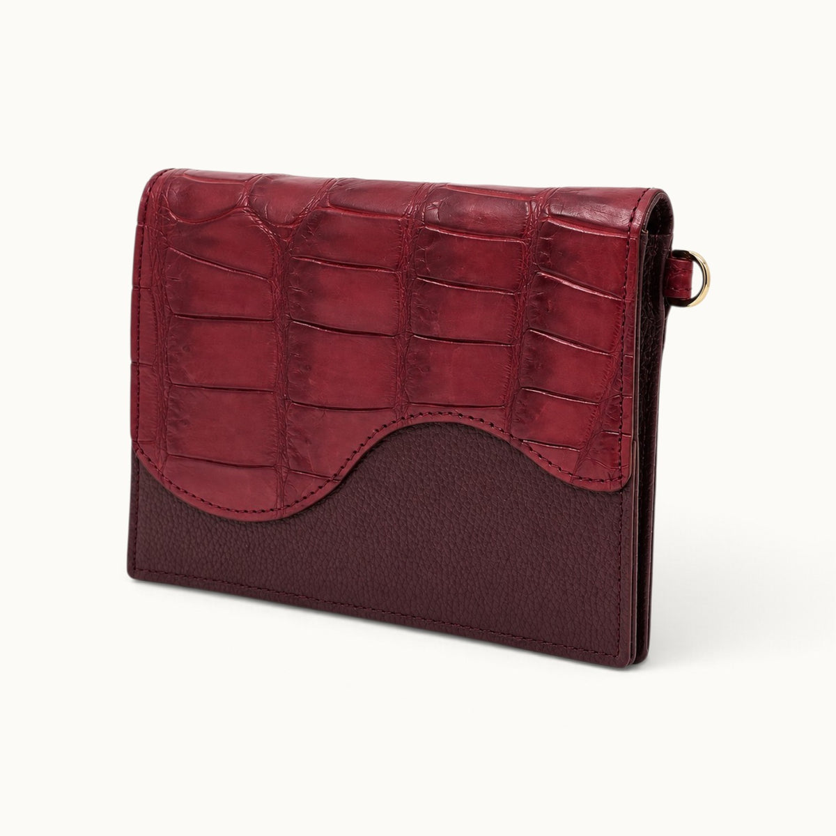 Angle view of The Berkeley Convertible Wallet in Burgundy, featuring genuine Siamese crocodile leather and a slim pebbled calf leather body.