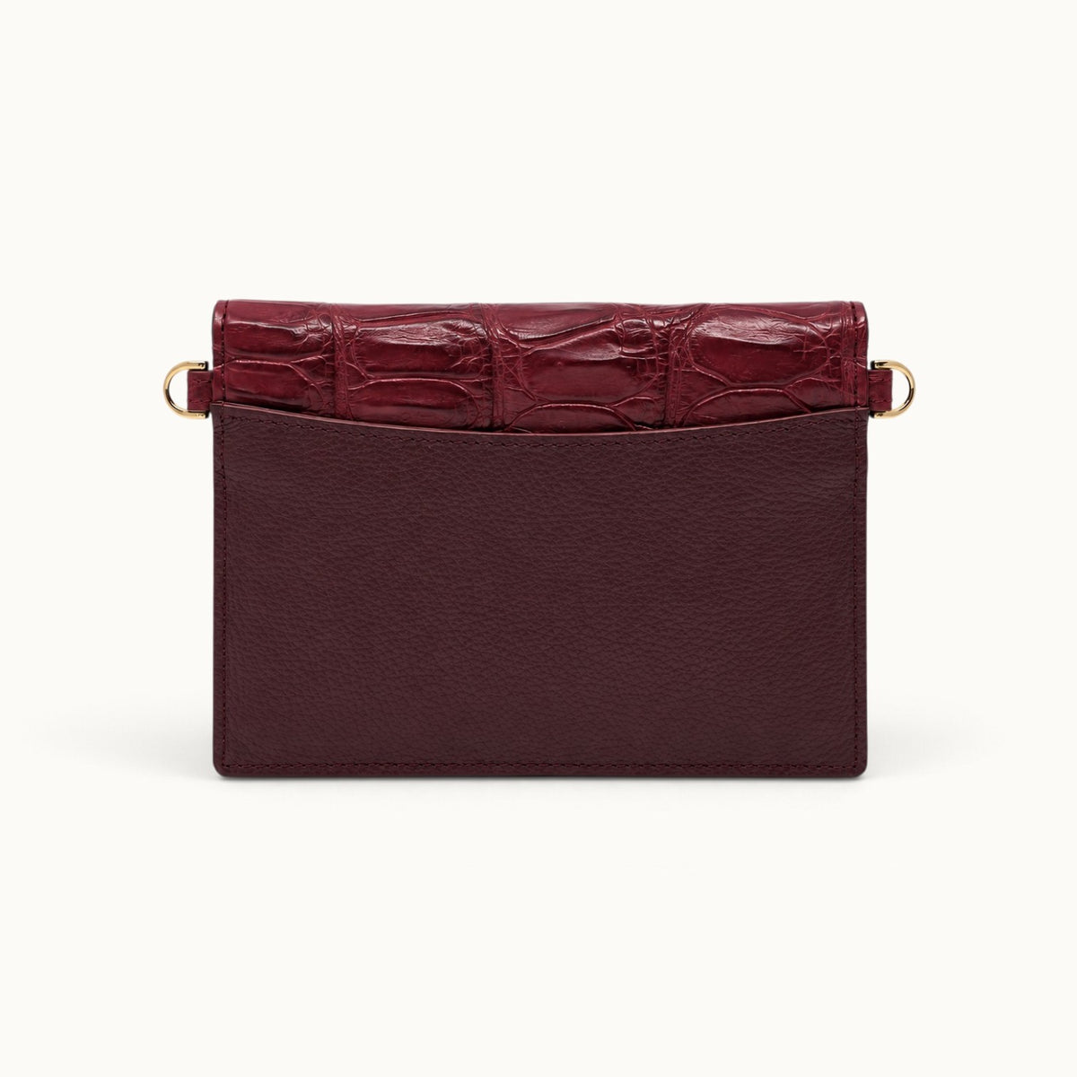 Back view of The Berkeley Crocodile Convertible Wallet in Burgundy with a slim exterior slip pocket, pebbled calf leather, genuine Siamese crocodile trim, and gold-tone D-rings.