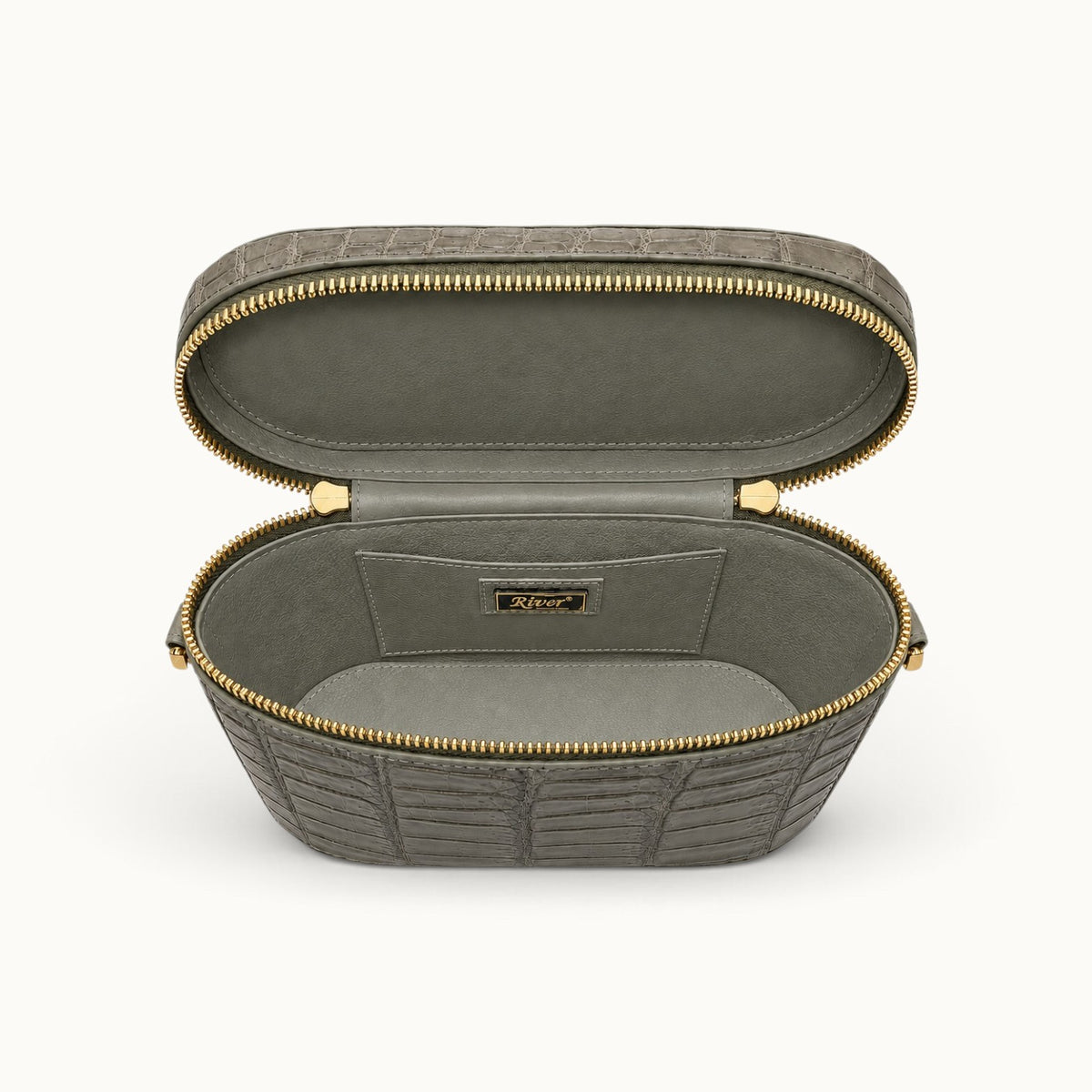 Interior view of The Clarendon Mini Box Bag in Sage Olive, handcrafted from genuine Siamese crocodile leather with full-grain cow leather lining, double zipper opening, and slip pockets.