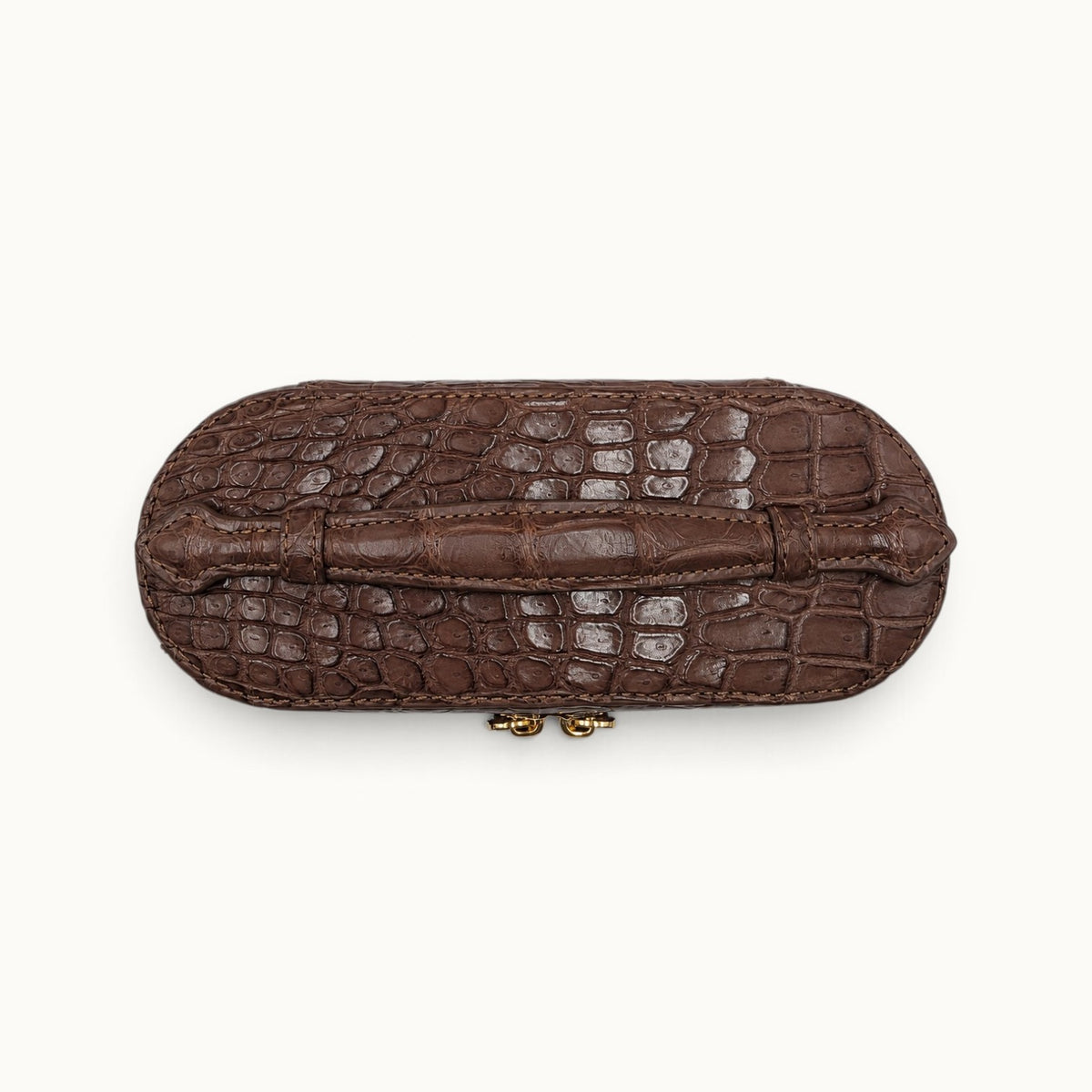 Top view of The Clarendon Cocoa Brown crocodile top handle mini bag with hand-finished edges and natural scale detail.