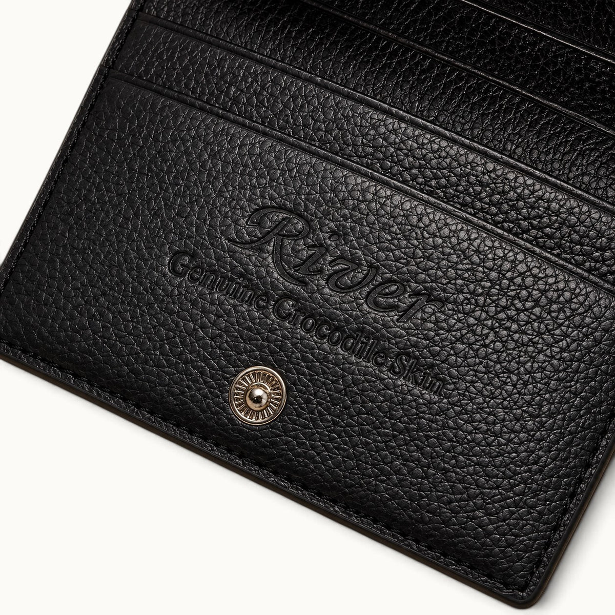 Interior detail of The Compact Crocodile Wallet in Classic Black showing the embossed River logo and full-grain leather