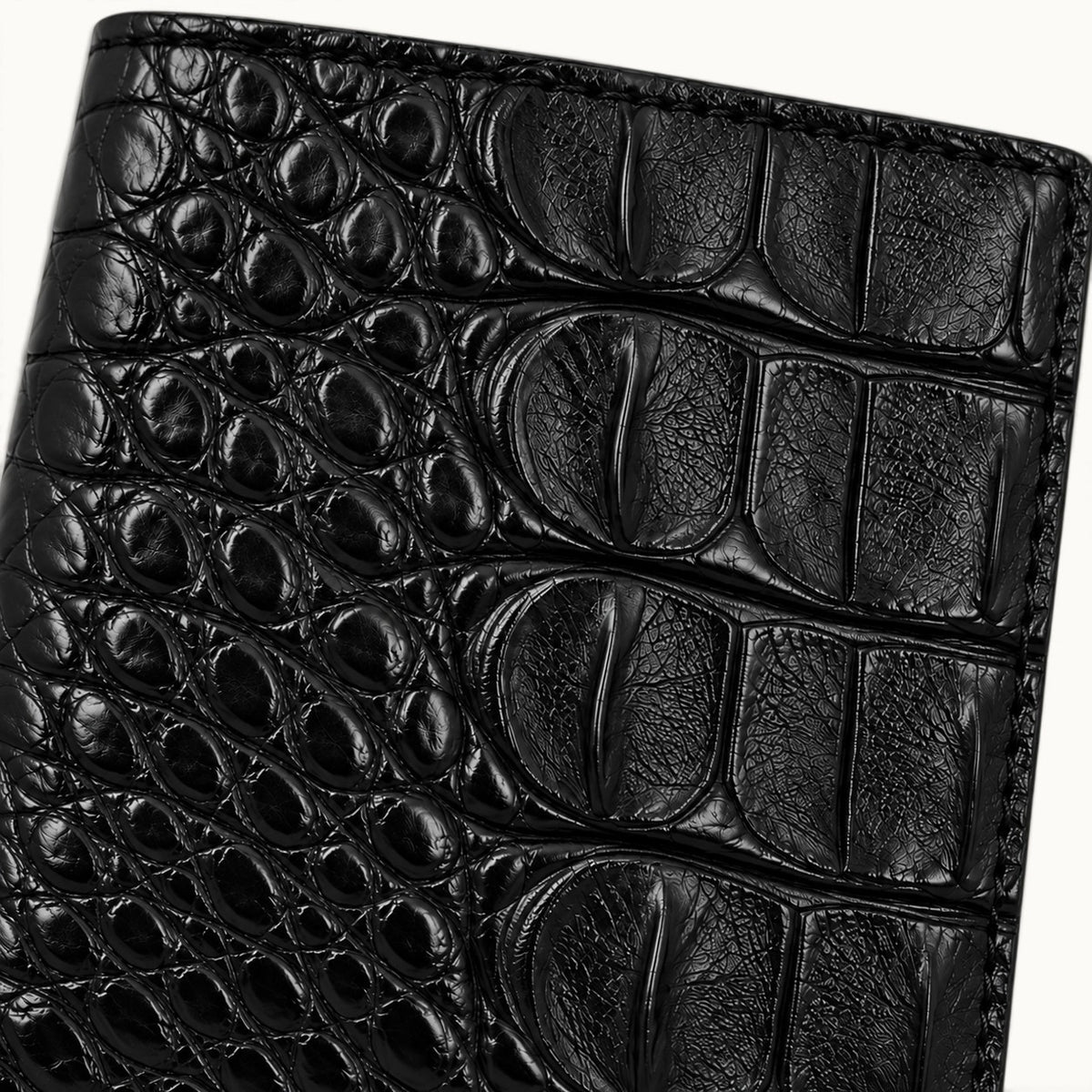 Close-up of Classic Black genuine Siamese crocodile leather showing natural scales, fine texture and detailed stitching