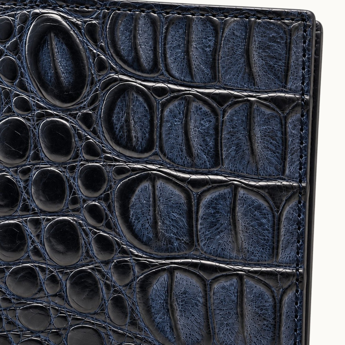 Close-up of Deep Navy genuine Siamese crocodile leather showing natural scales, fine texture and detailed stitching