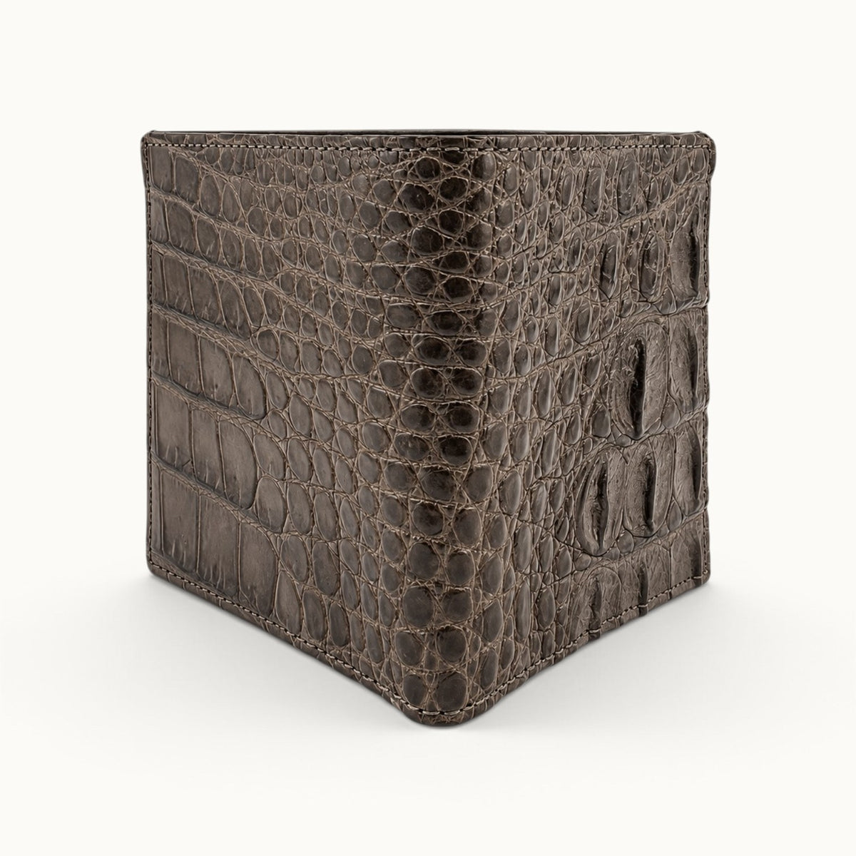 Three-quarter view of The Compact Crocodile Wallet in Taupe Green showing its bifold construction and natural crocodile leather pattern