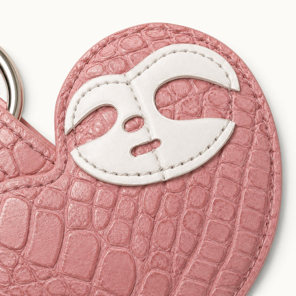 Close-up of the white leather mask motif on the Blush Pink Crocodile Palette Bag Charm