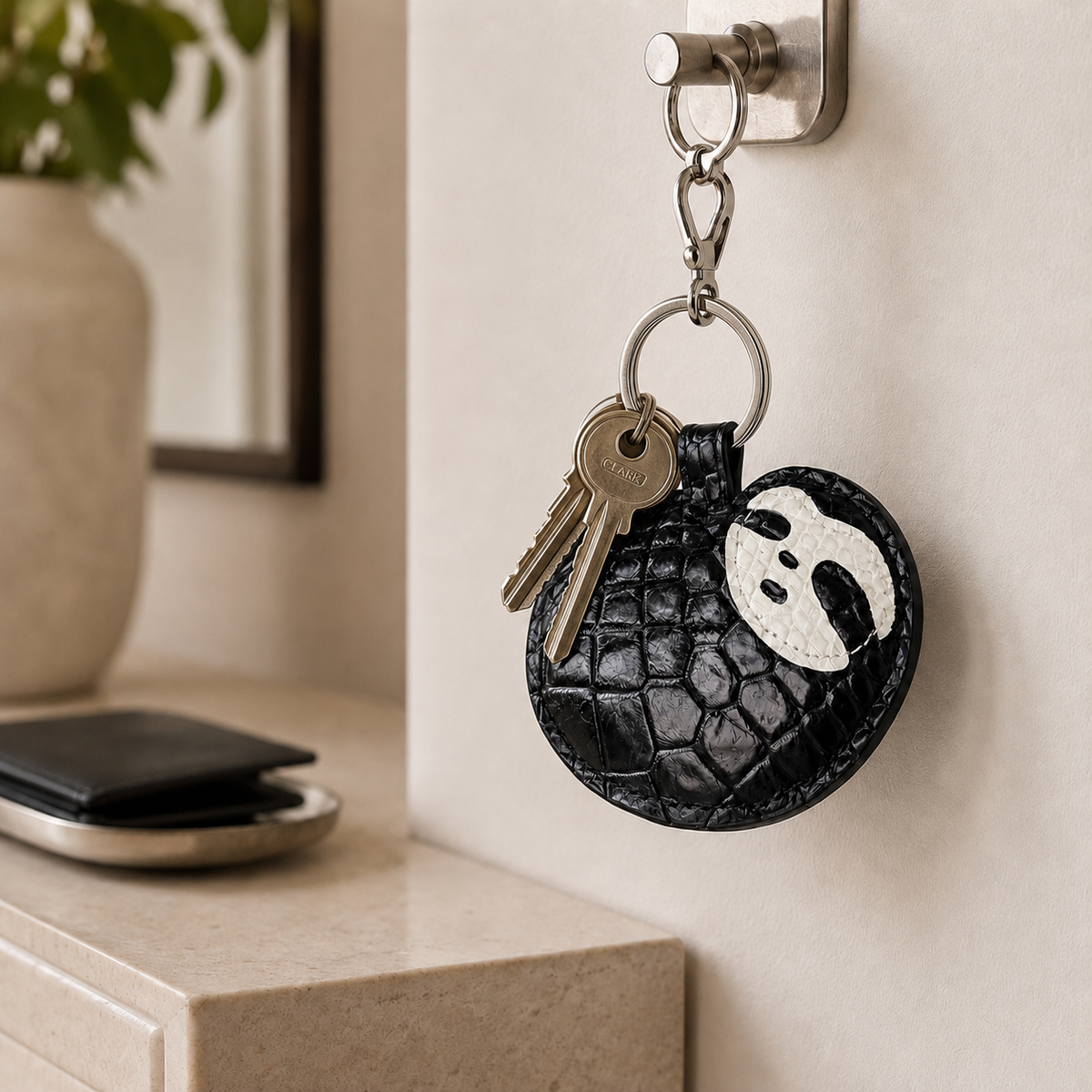 Jet Black Crocodile Palette Bag Charm with keys hanging from an entryway wall hook