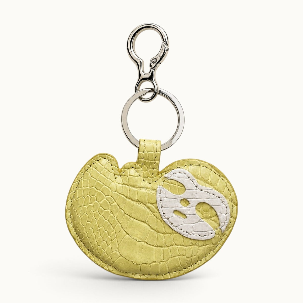 Mustard Yellow Crocodile Palette Bag Charm front view showing natural crocodile scale pattern and white mask motif