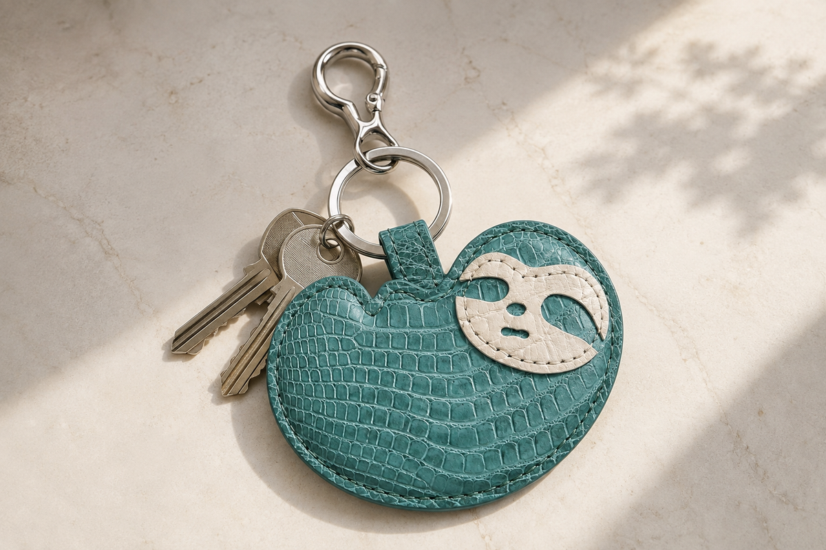 Seafoam Green Crocodile Palette Bag Charm with everyday keys on a light stone surface