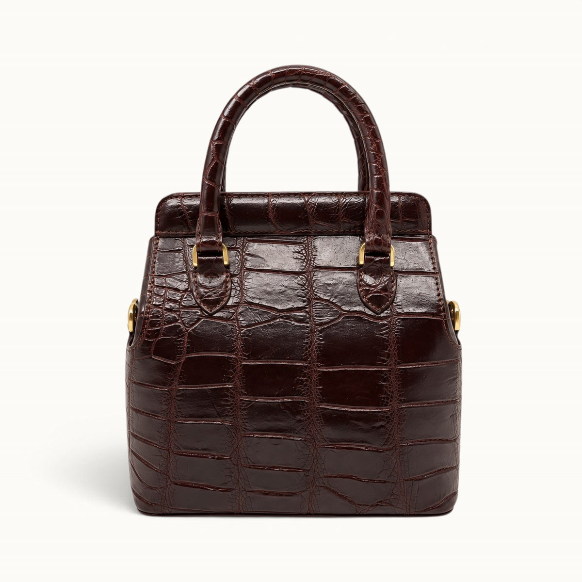 Front view of The Ellery Crocodile Handbag in Bordeaux, showcasing its structured silhouette, distinctive crocodile texture, and gold-tone hardware.