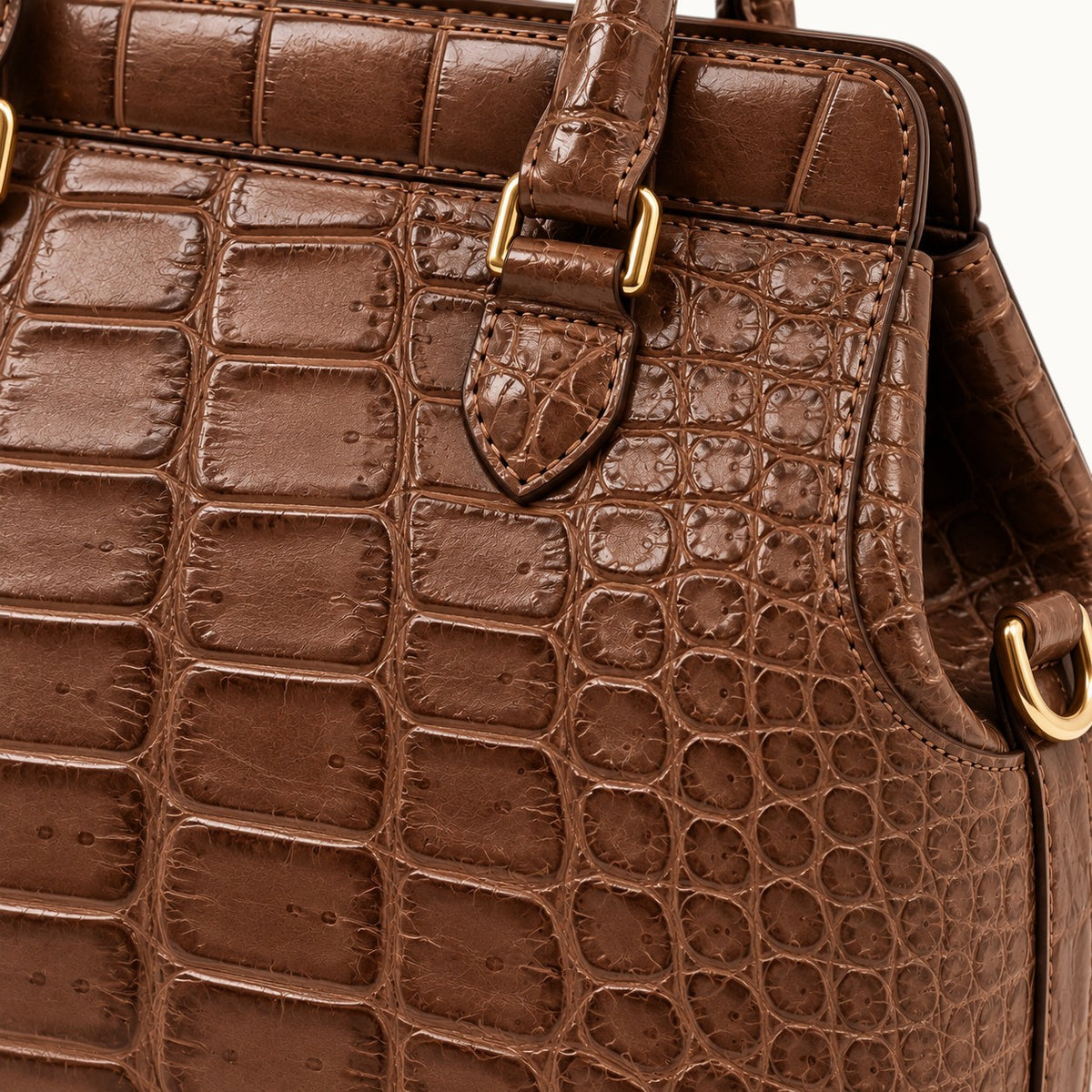Close-up of The Ellery Crocodile Handbag in Cocoa Brown, highlighting natural crocodile scales, fine stitching, and polished gold-tone hardware.