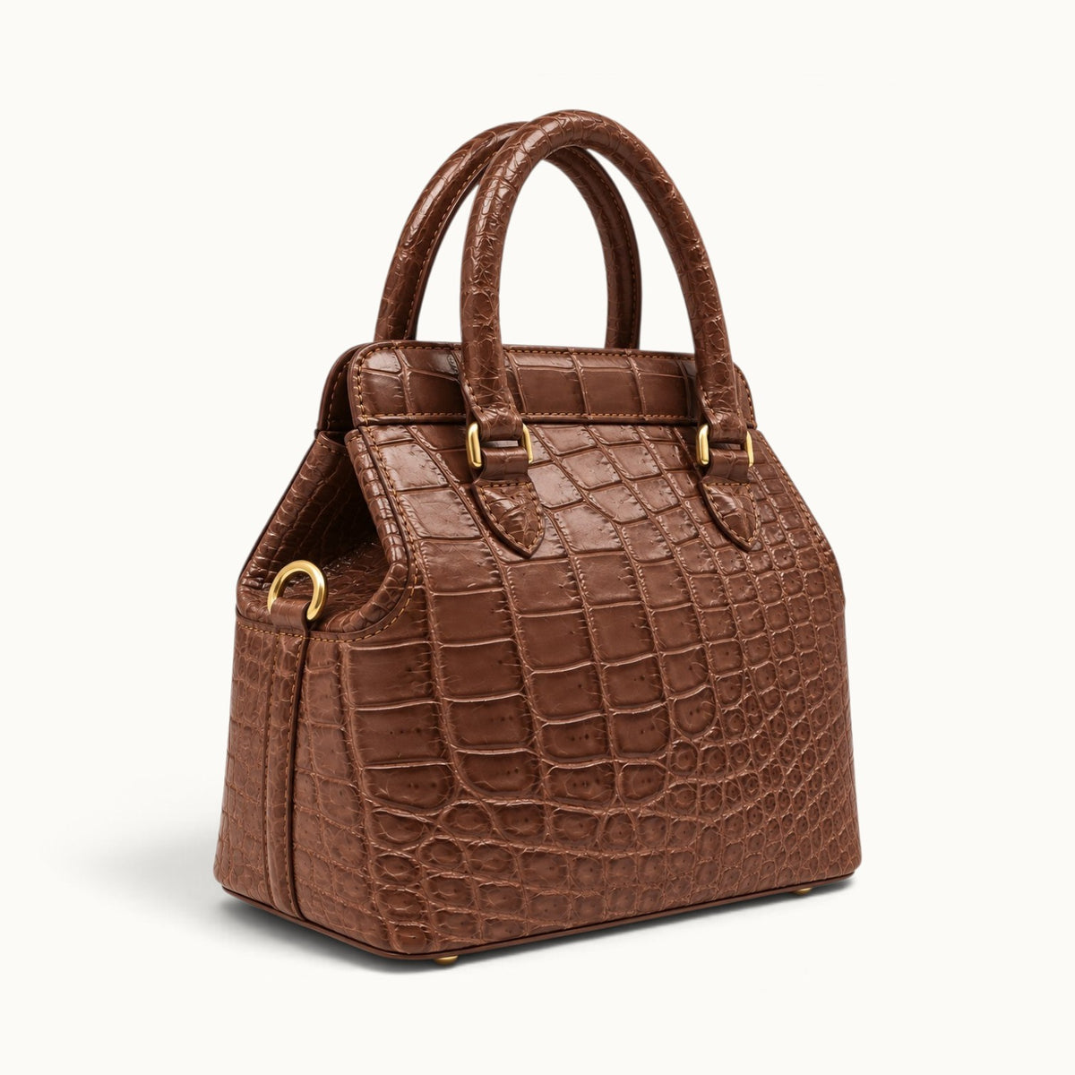 Three-quarter studio view of The Ellery Crocodile Handbag in Cocoa Brown, showing its natural crocodile scale pattern, side gusset, and gold D-ring.