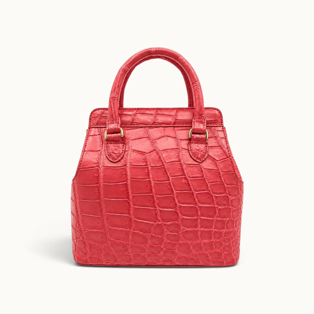 Front view of The Ellery Crocodile Handbag in Coral Pink, featuring natural crocodile scales, rolled leather handles, and gold-tone hardware.