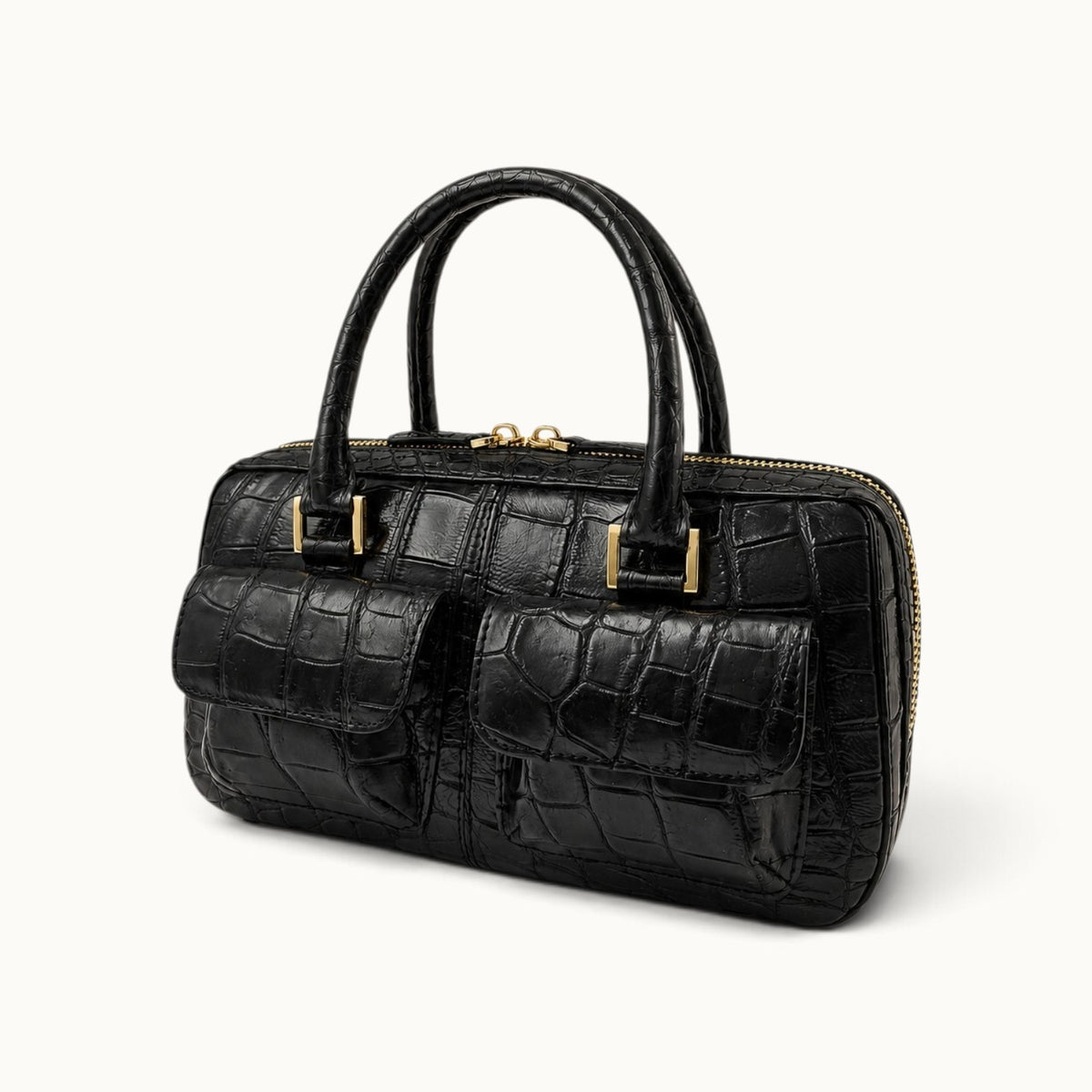 Fairmont Siamese crocodile handbag in Classic Black shown from a three-quarter angle with two front pockets and gold-tone hardware.