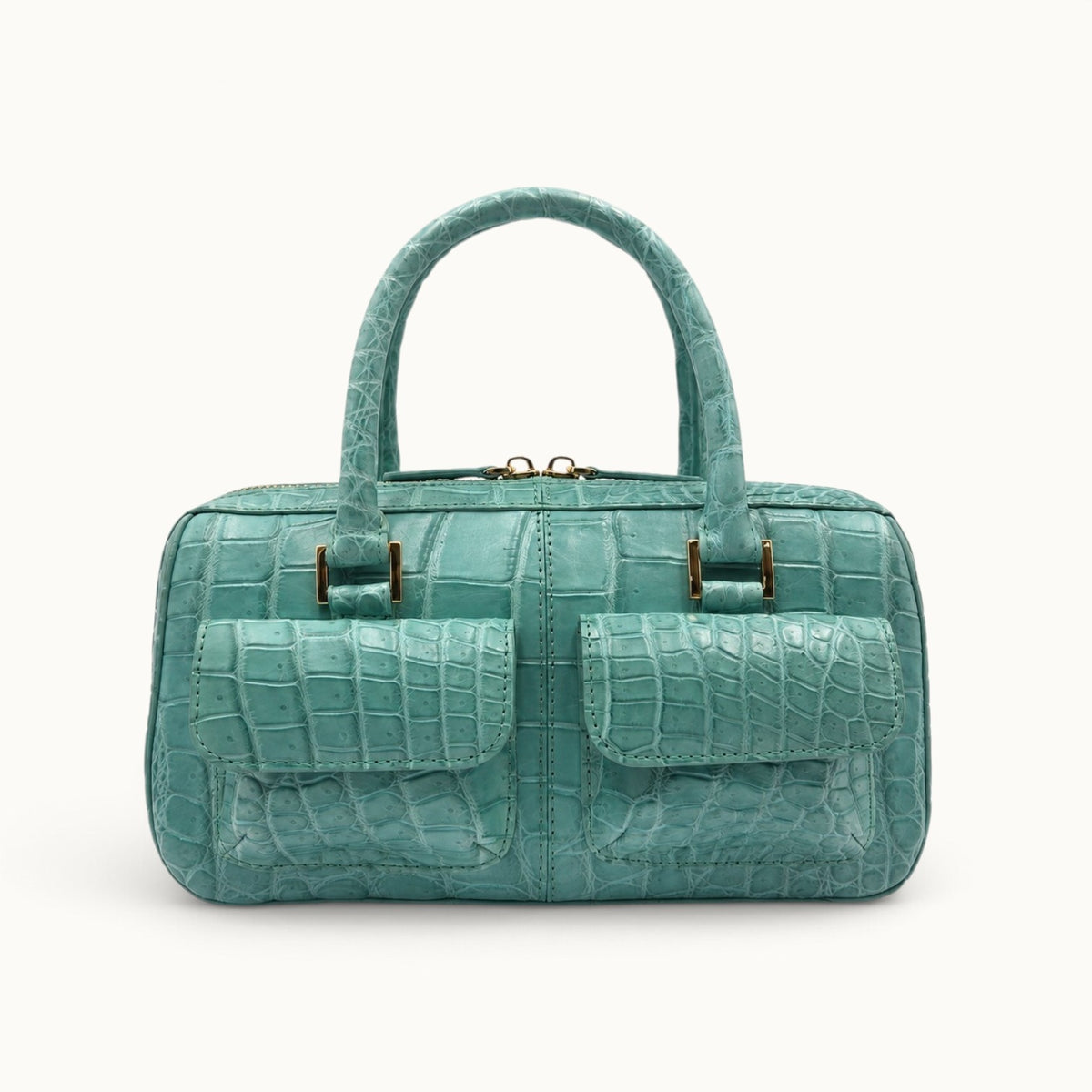 Front hero view of the Fairmont Siamese crocodile handbag in Seafoam Green with two exterior flap pockets and gold-tone hardware.