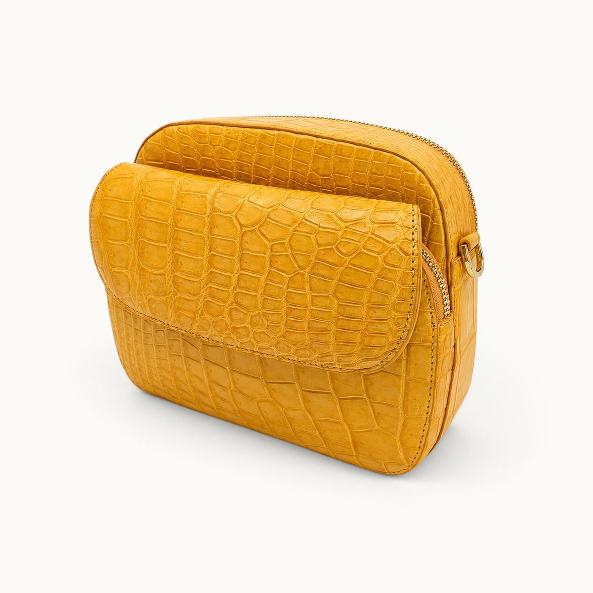 Three-quarter angle view of the Grosvenor Siamese crocodile crossbody bag showing the front flap and side construction.