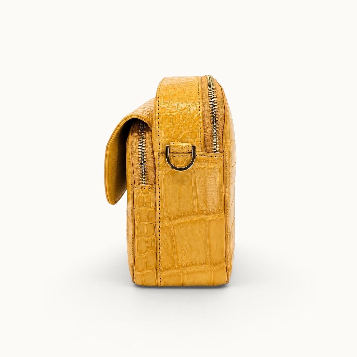 Side view of the Grosvenor Siamese crocodile crossbody bag with D-ring and zippered compartments.