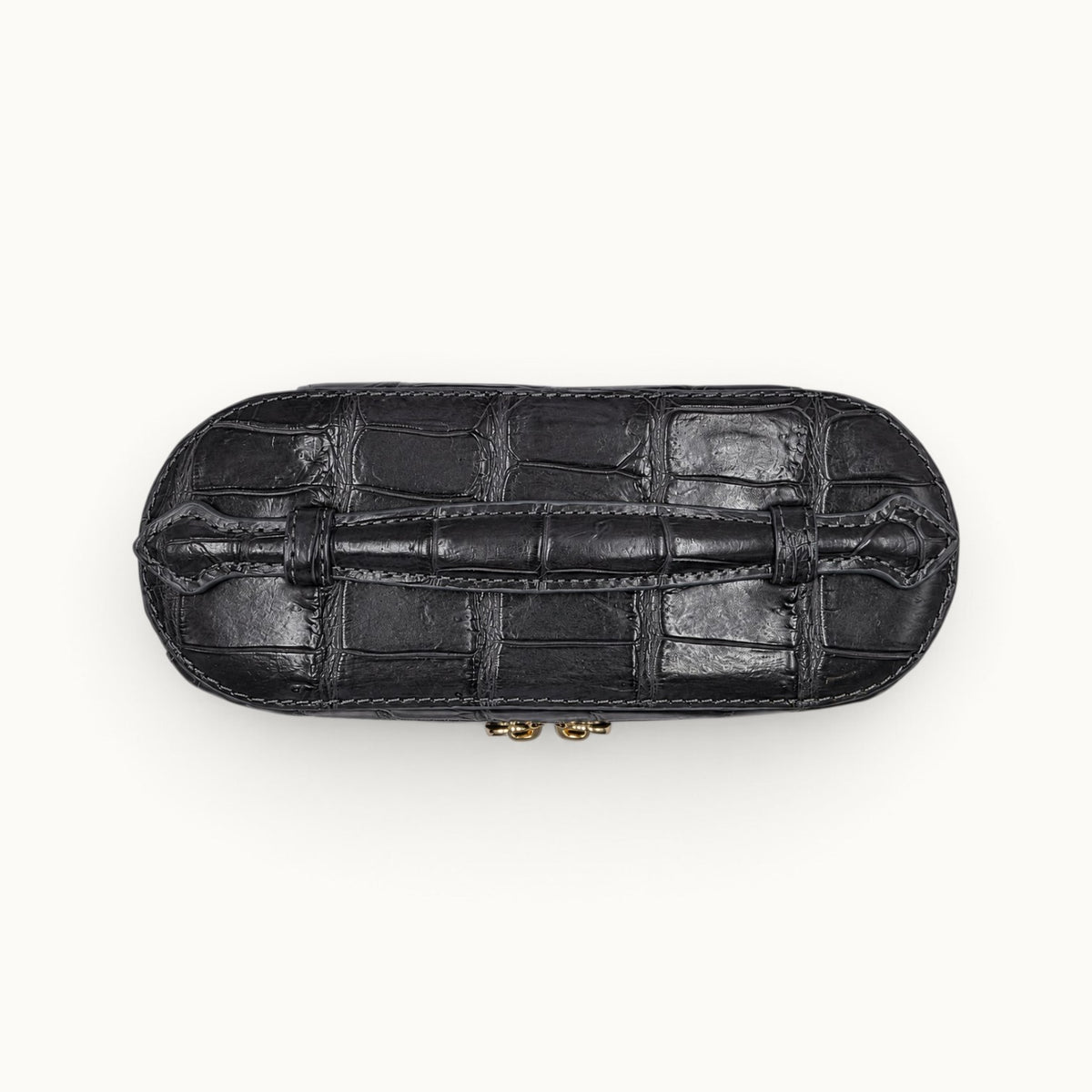Top view of The Clarendon Gunmetal Gray crocodile vanity case showing the raised crocodile handle and hand-finished top panel.