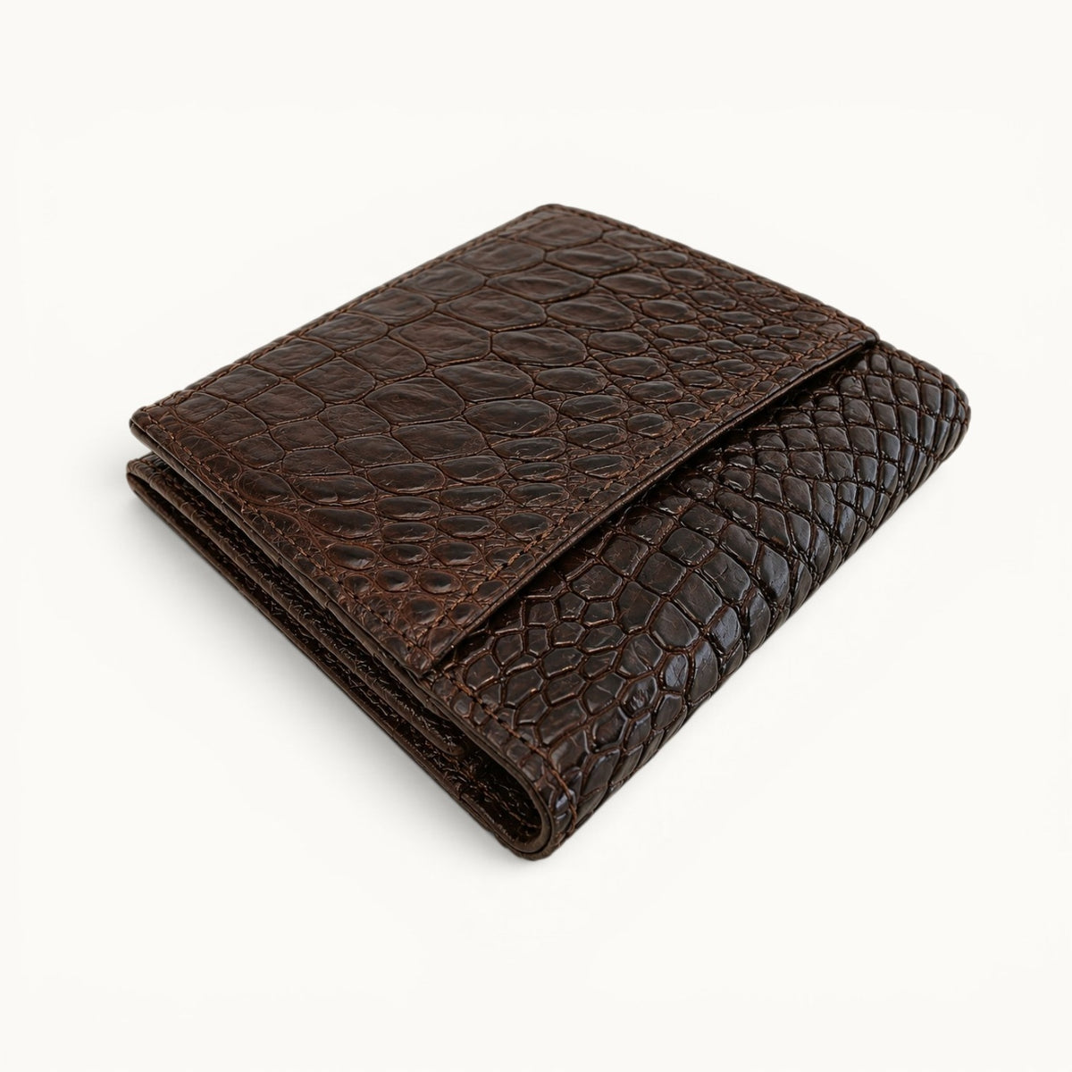 Herrington Espresso Brown Siamese crocodile trifold wallet shown folded from above, highlighting its layered construction, rear slip pocket, and compact profile.