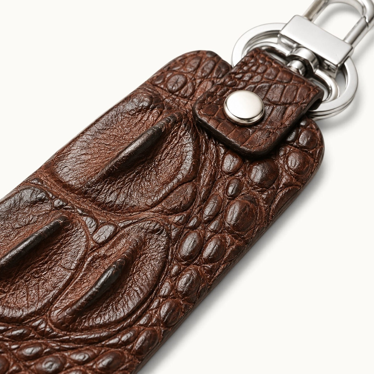 Close-up of the Kensington brown genuine alligator leather key fob showing raised hornback scales, natural grain, and polished silver-tone hardware.