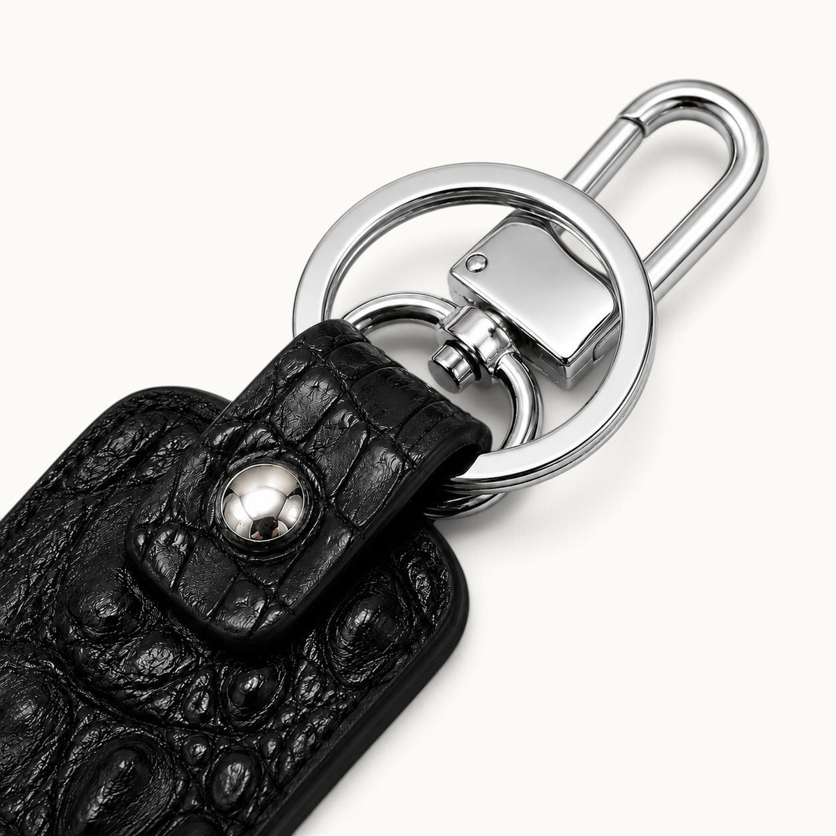 Close-up of the Kensington black genuine alligator leather key fob showing the polished silver-tone swivel clasp, large key ring, snap closure, and natural scale texture.