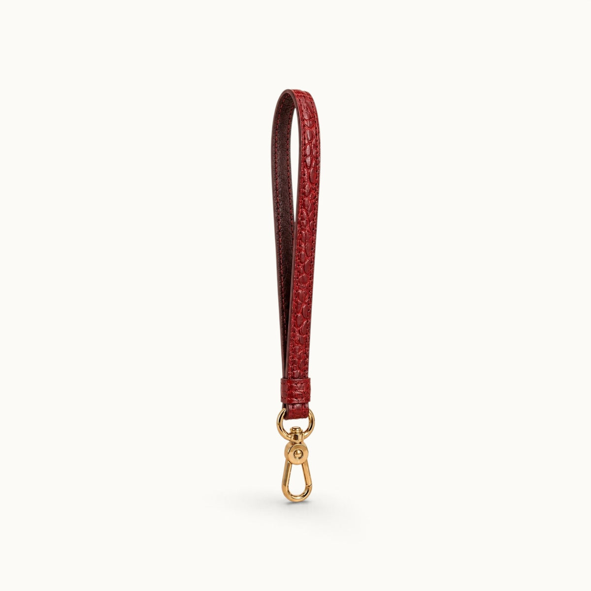Angled view of the Burgundy Red Stanhope crocodile wrist strap showing the crocodile texture, cow leather interior, and gold-tone clasp.