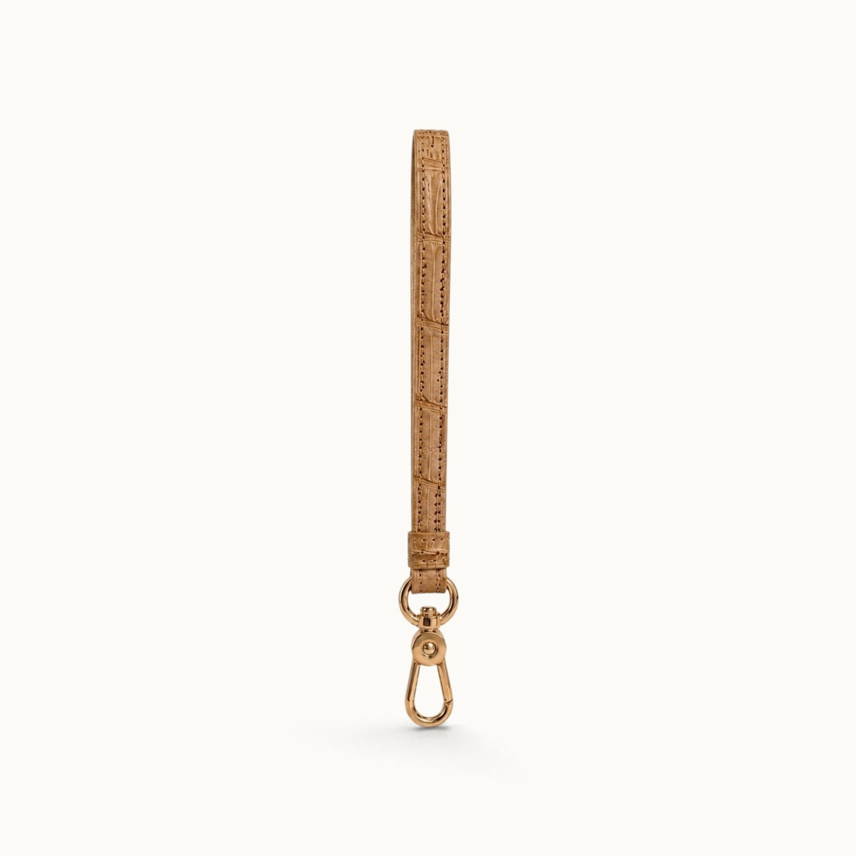 Full-length front view of the Sand Beige Stanhope crocodile wrist strap with polished gold-tone clasp.