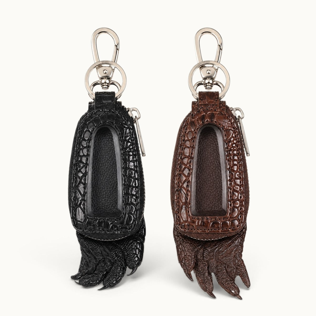 Black and brown Siamensis crocodile leather car key cases displayed side by side with clear front windows, silver hardware, and sculpted claw details.