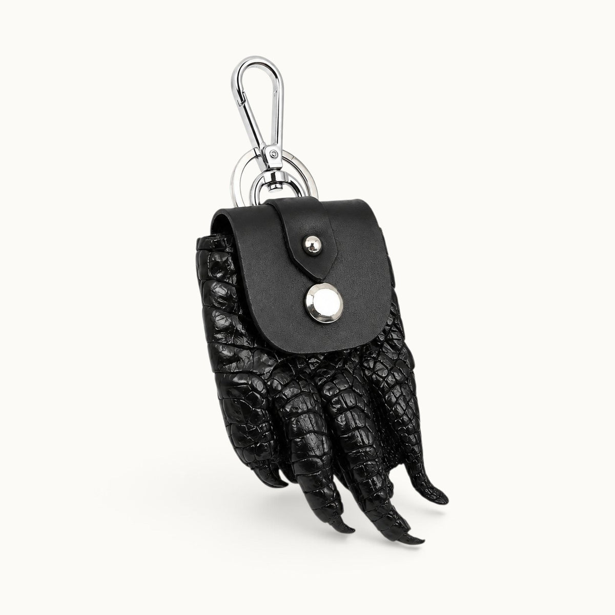 The Claw Crocodile Coin Pouch in black shown from a three-quarter angle with silver clasp and key ring
