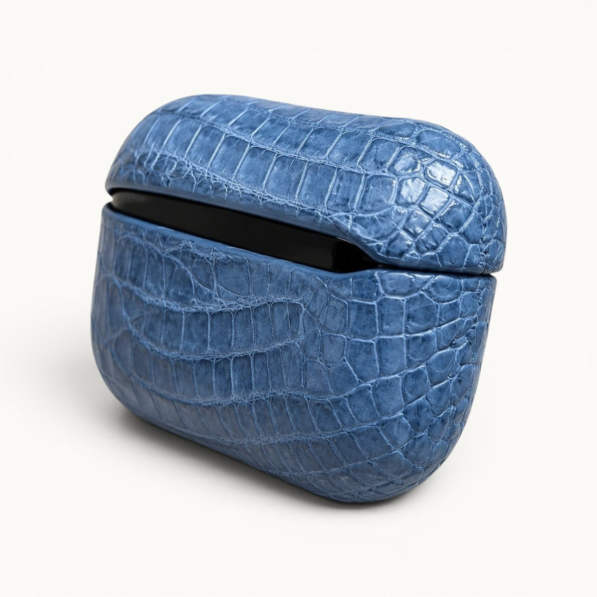 Rear three-quarter view of The Crocodile AirPods Case in French Blue featuring genuine Siamese crocodile leather and a precision-molded protective shell.