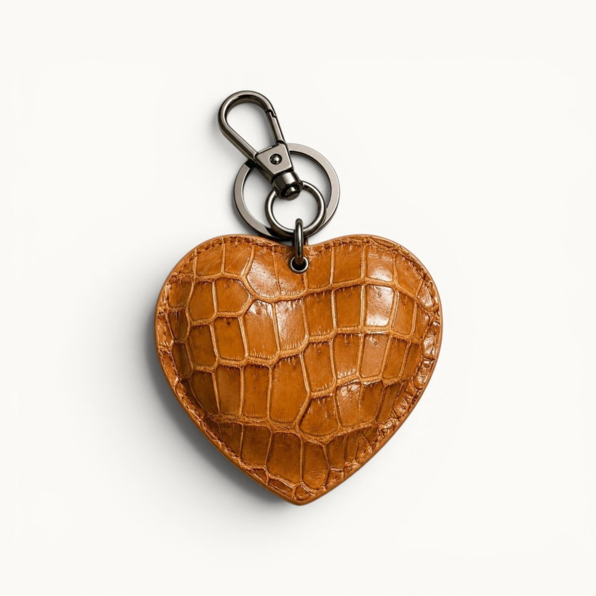 The Heart Key Charm in caramel Siamese crocodile leather with natural scales, stitched edges, and polished silver-tone key holder hardware.