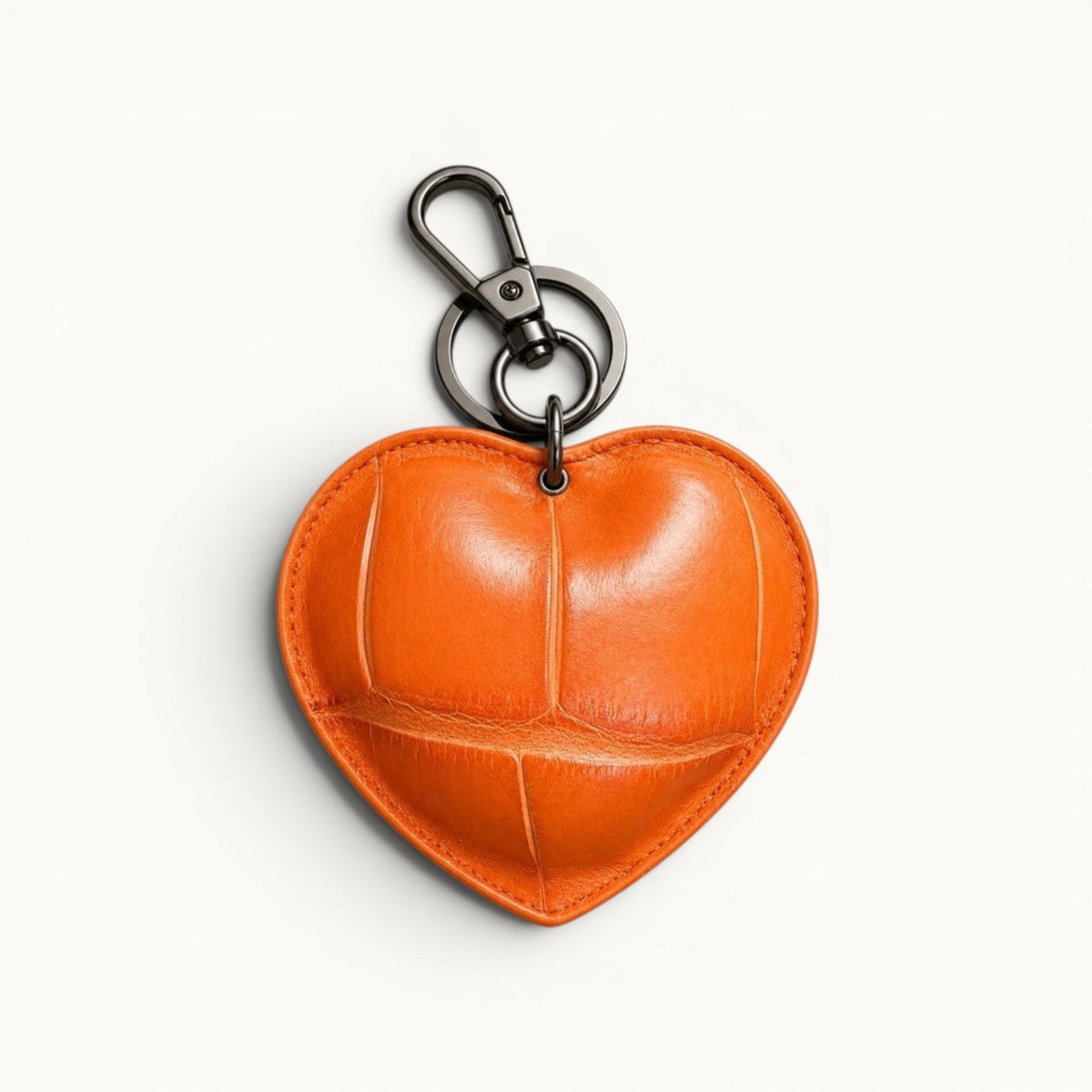 The Heart Key Charm in vibrant orange Siamese crocodile leather with bold natural scales, stitched edges, and polished silver-tone hardware.