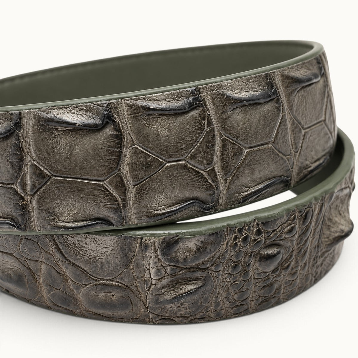 Macro close-up of The Waverly Crocodile Belt highlighting two rows of raised Siamese crocodile backstrap scales and natural semi-gloss leather texture.