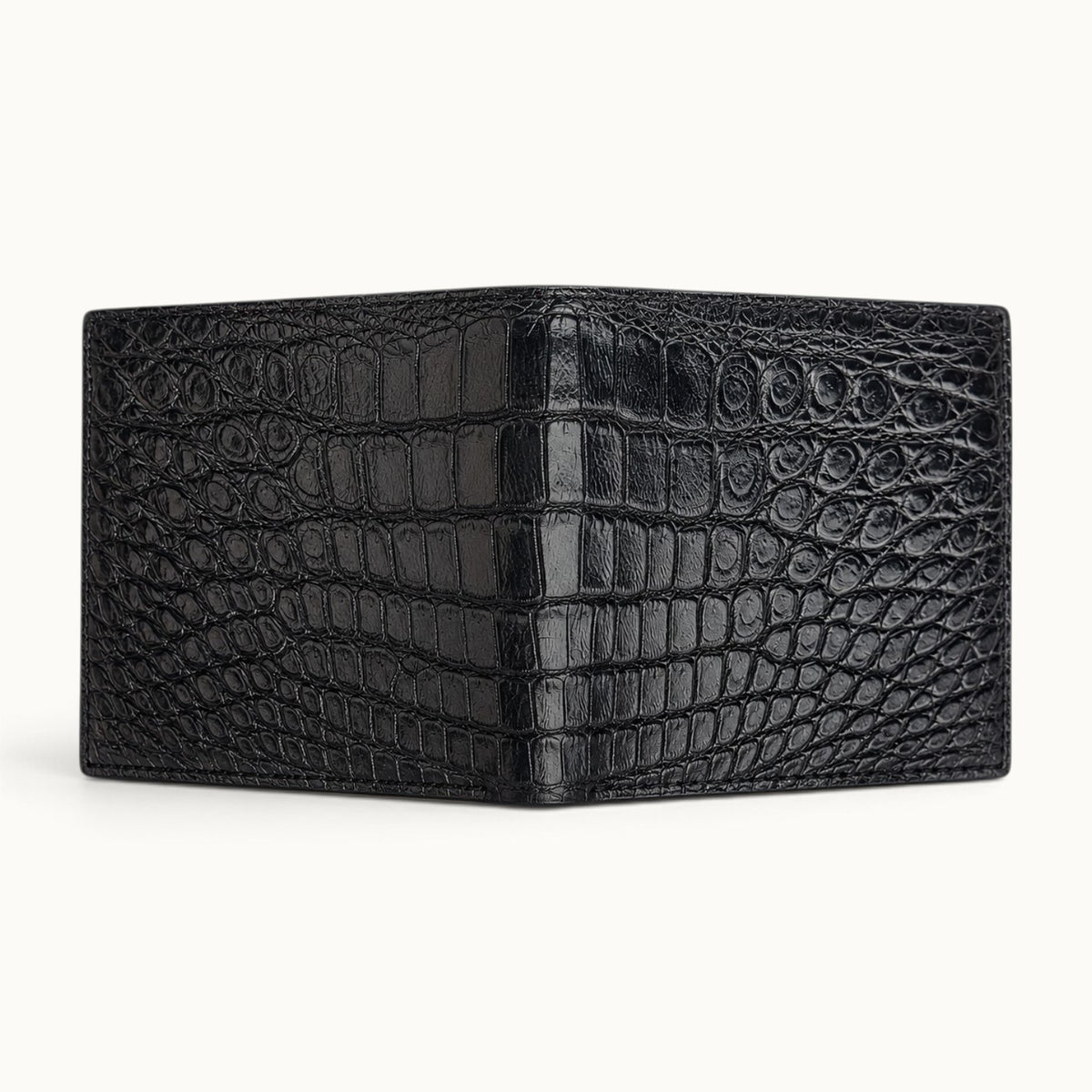 Full open exterior view of The Ashford black Siamese crocodile bifold wallet, showcasing the continuous full-belly cut and distinctive natural scale pattern.
