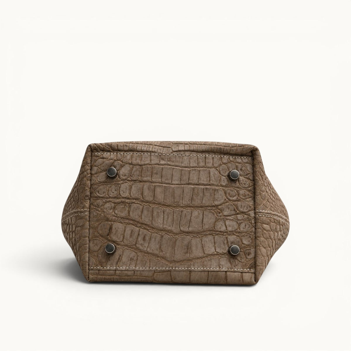 Bottom view of The Atelier Tote handcrafted from genuine Porosus crocodile leather, featuring a structured full-grain leather base with protective metal feet.