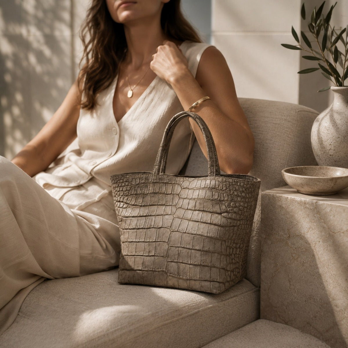 The Atelier Tote handcrafted from genuine Porosus crocodile leather, displayed in a refined lifestyle setting that highlights its timeless elegance and distinctive natural scale pattern.