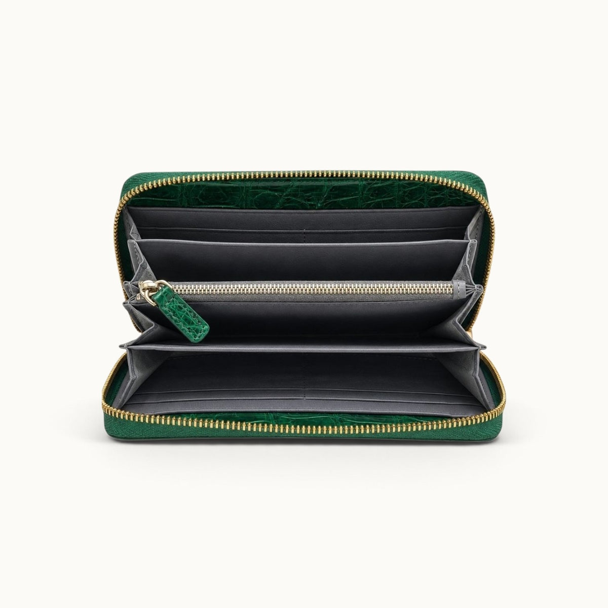 Front interior view of the Belvedere Siamese crocodile zip-around wallet in Emerald Green showing gray lambskin lining, card slots, spacious compartments, and central zip pocket