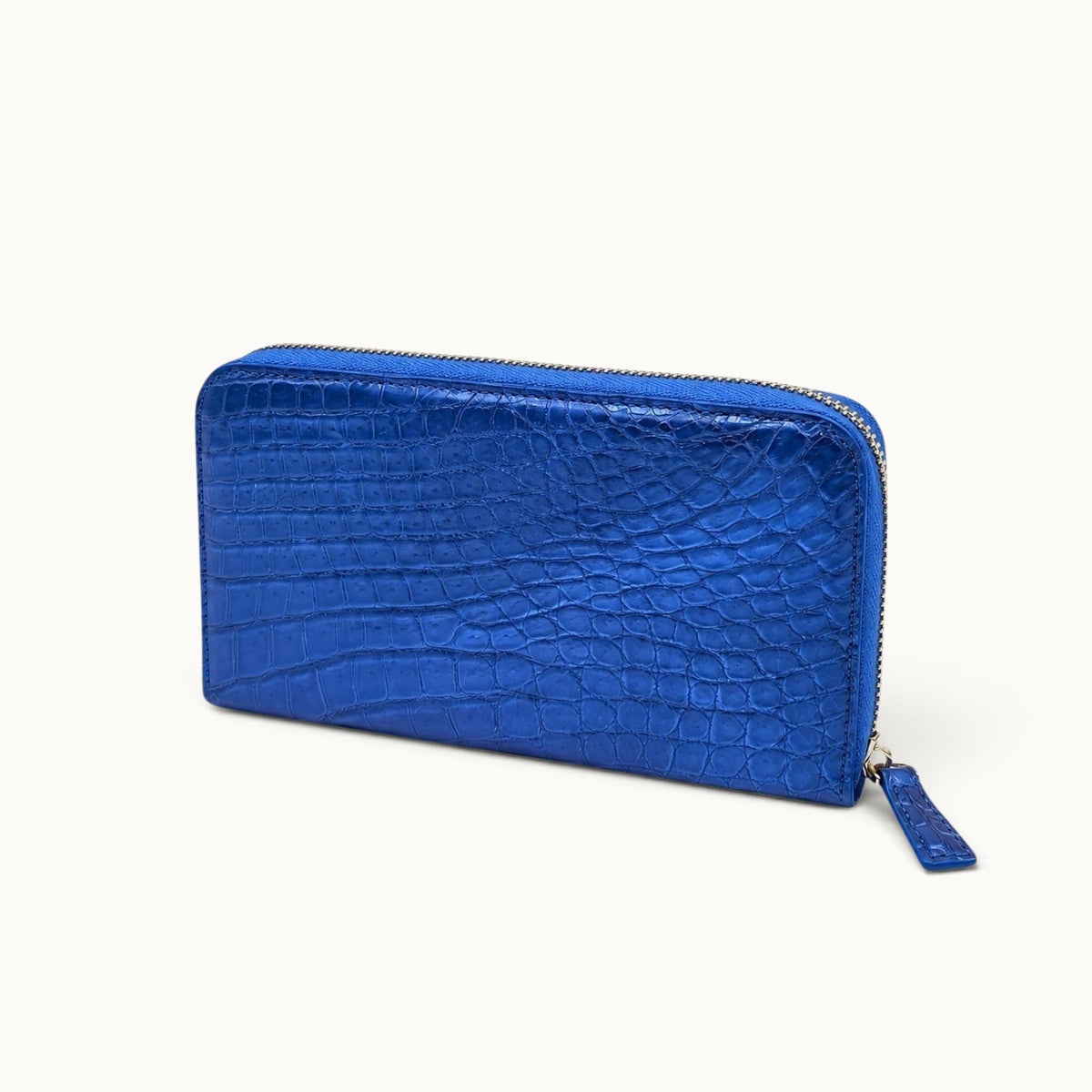 Angled view of the Belvedere Siamese crocodile zip-around wallet in Royal Blue with natural scale pattern and gold-tone hardware