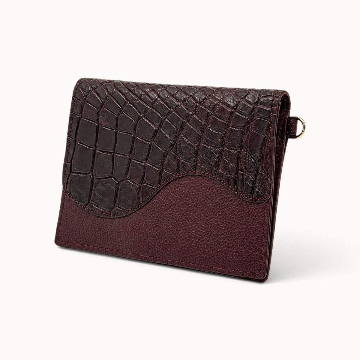 Angle view of The Berkeley Convertible Wallet in Bordeaux, crafted from genuine Siamese crocodile leather and soft pebbled calf leather.