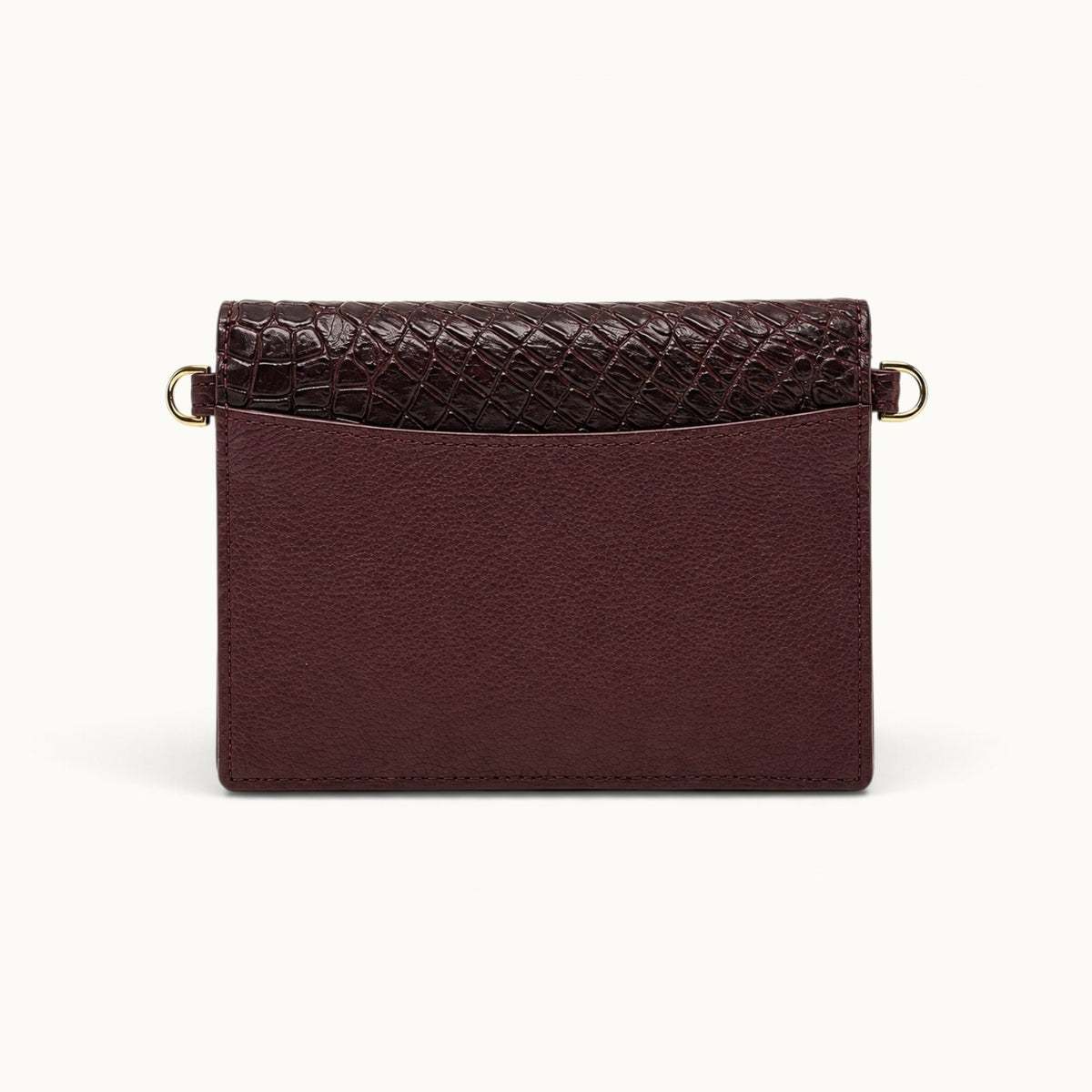 Back view of The Berkeley Crocodile Convertible Wallet in Bordeaux with a slim exterior slip pocket, pebbled calf leather, genuine Siamese crocodile trim, and gold-tone D-rings.