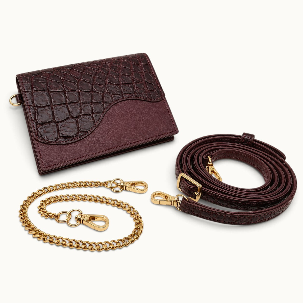 The Berkeley Crocodile Convertible Wallet in Bordeaux with removable gold-tone chain and matching adjustable crocodile leather shoulder strap.