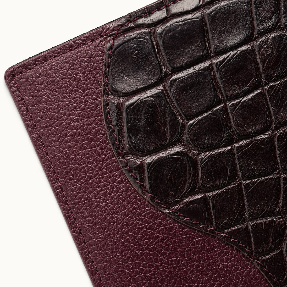 Close-up texture detail of The Berkeley Crocodile Convertible Wallet in Bordeaux showing genuine Siamese crocodile leather, pebbled calf leather, and refined edge stitching.