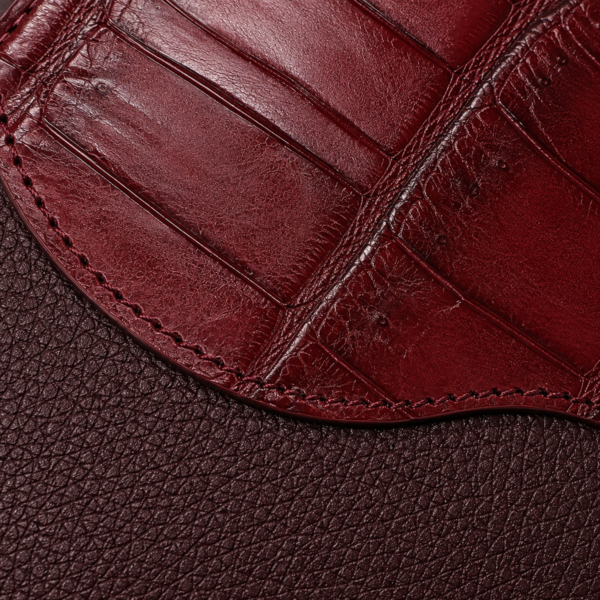 Close-up texture detail of The Berkeley Crocodile Convertible Wallet in Burgundy highlighting genuine Siamese crocodile leather, pebbled calf leather, and handcrafted stitching.