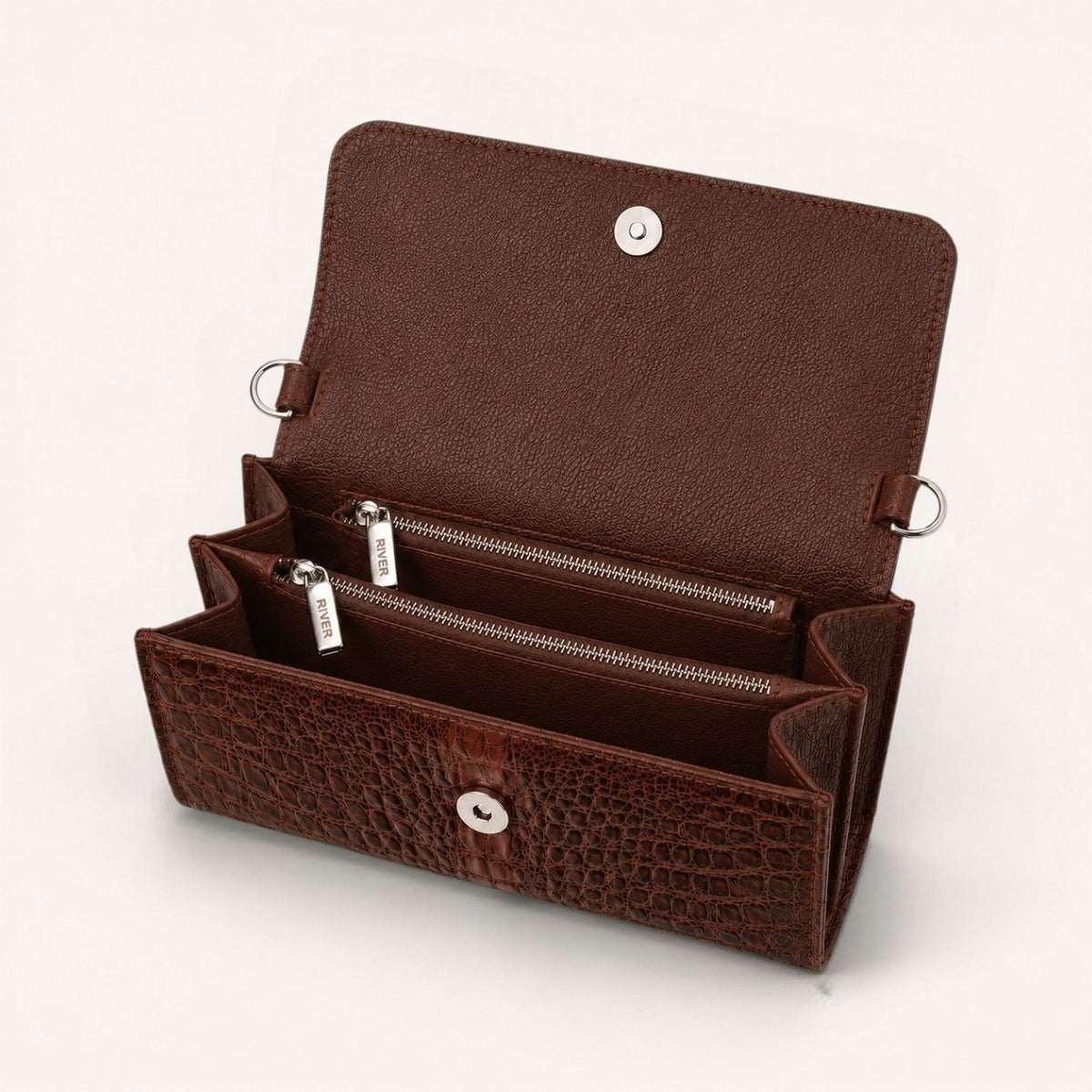 Open interior view of The Cavendish genuine caiman leather shoulder clutch bag, showing two zippered compartments, full-grain cow leather lining, magnetic closure, and RIVER zipper pulls.