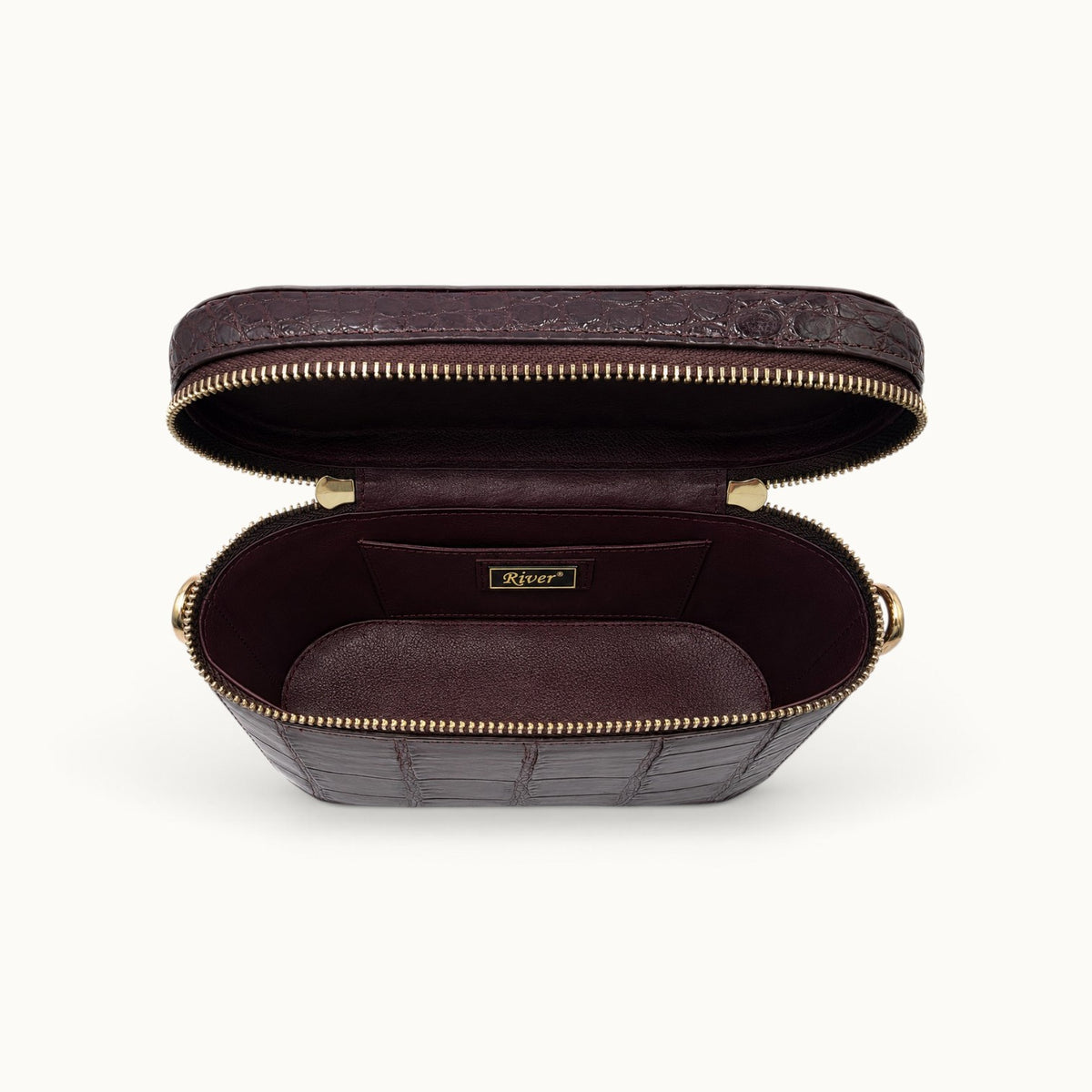 Interior view of The Clarendon Mini Box Bag in Bordeaux with genuine Siamese crocodile leather, full-grain cow leather lining, double YKK zipper opening, and two slip pockets for elegant everyday organization.